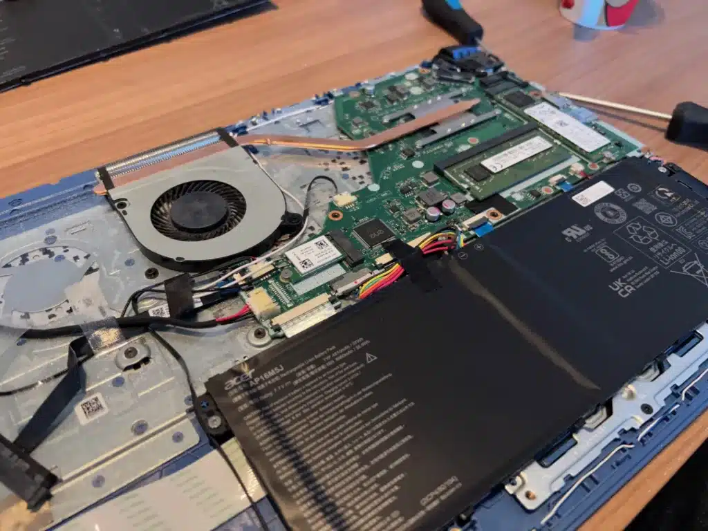 Opengewerkte laptop op de werktafel van Uwish-IT tijdens een herstelling