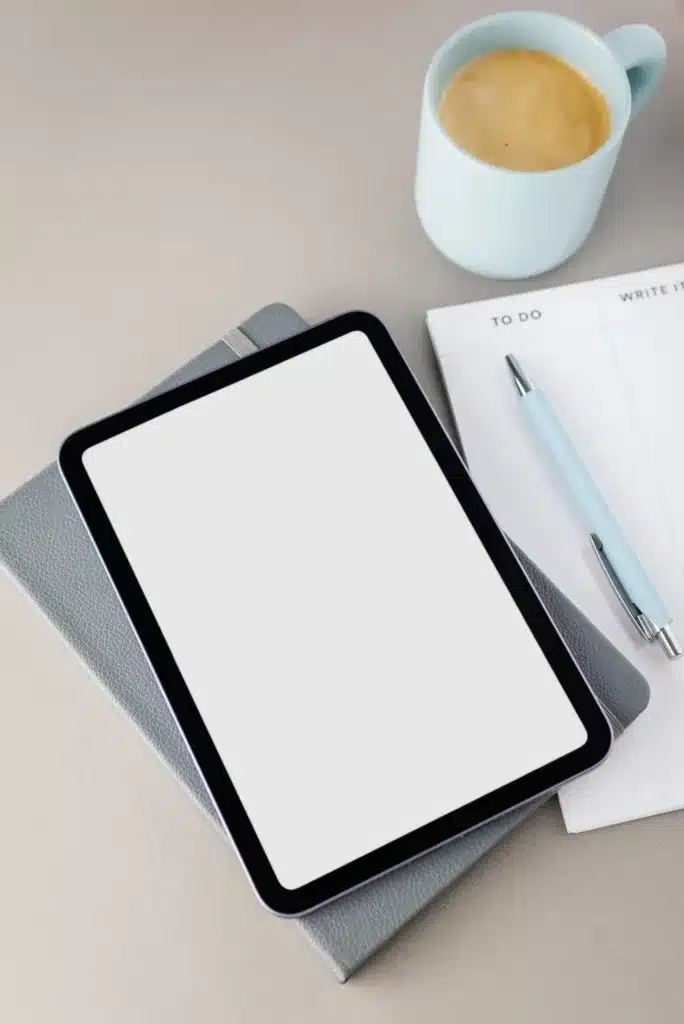 Tablet, notitieblok en koffie tijdens een brainstorm over een website